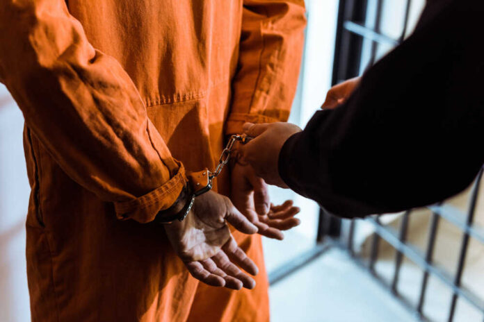 Cropped,Image,Of,Prison,Officer,Wearing,Handcuffs,On,Prisoner