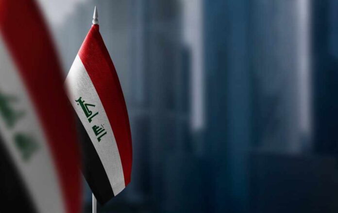 Small,Flags,Of,Iraq,On,A,Blurry,Background,Of,The