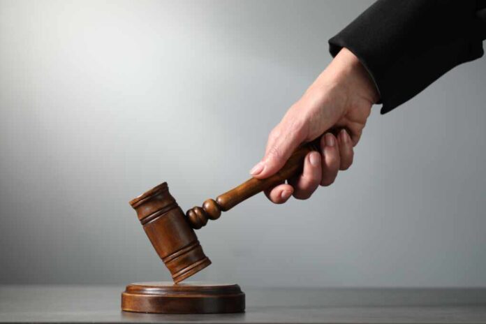 Judge,Striking,Mallet,At,Table,Against,Grey,Background,,Closeup.,Space