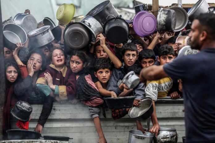 Displaced,Palestinians,In,Al-mawasi,Crowd,To,Get,Rice,Meals,From