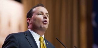 A man in a suit delivering a speech at a podium