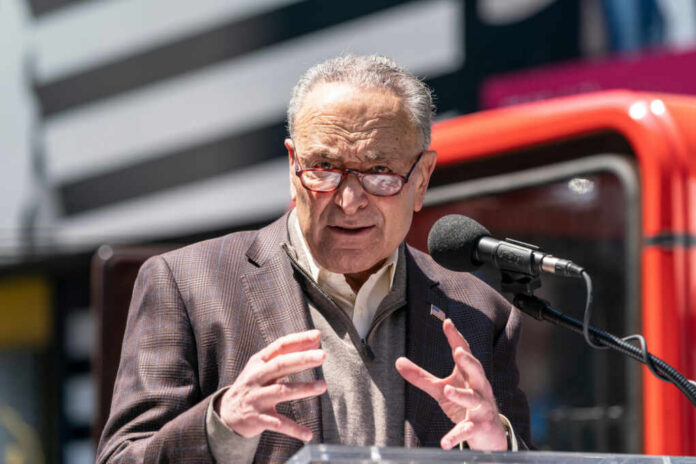 A man in a blazer speaking passionately at a podium with a microphone