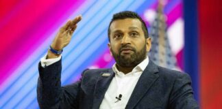 A speaker gesturing while addressing an audience at a conference