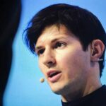 A speaker presenting at a conference with a microphone
