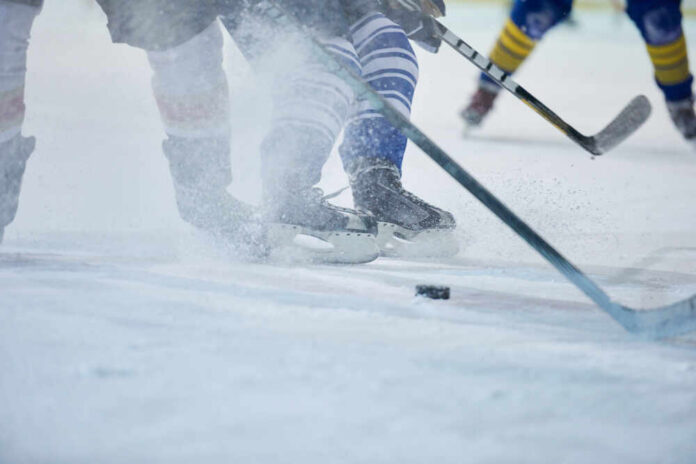 Ice hockey players competing on the rink with a puck in play