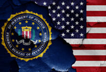 FBI emblem partially obscured by a cracked wall with an American flag background