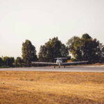 Teen Pilot Lands on FL Highway – Miracle A small airplane on a runway surrounded by trees