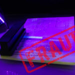 A passport under UV light with a stamp indicating fraud