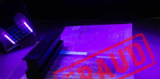 A passport under UV light with a stamp indicating fraud