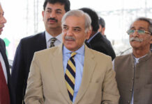 Group of men in formal attire engaged in conversation outdoors