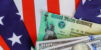 Close-up of U.S. currency with a backdrop of the American flag