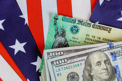 Close-up of U.S. currency with a backdrop of the American flag