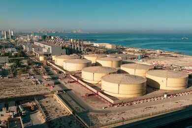 Aerial view of large oil storage tanks near a coastal area