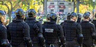 Group of police officers in riot gear facing away from the camera