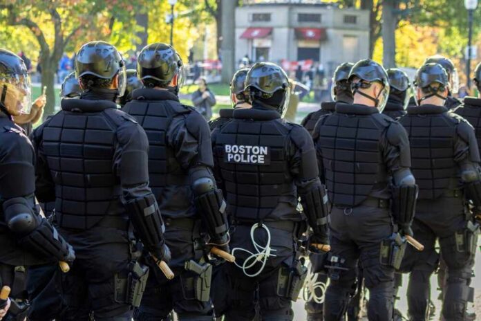Group of police officers in riot gear facing away from the camera