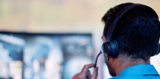 A surveillance operator wearing a headset while monitoring multiple screens