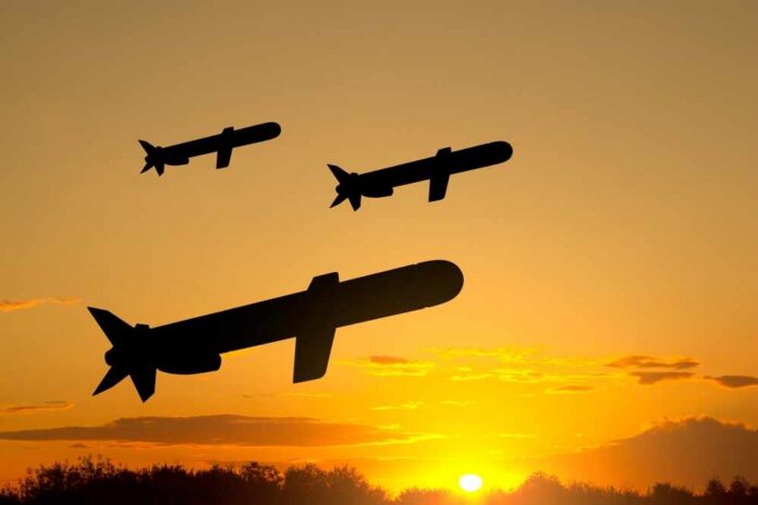 Silhouetted missiles flying against a sunset backdrop