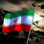 Iranian flag waving against a dark, cloudy sky
