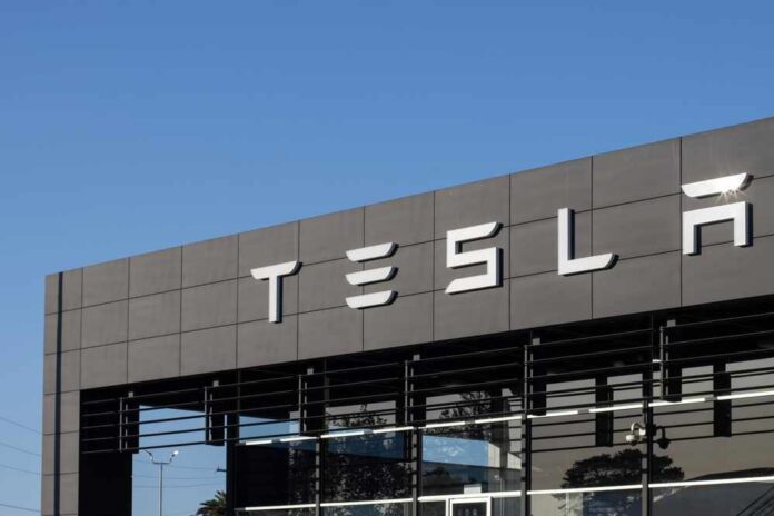 shutterstock_2526047677.jpg Exterior view of a Tesla dealership with the logo prominently displayed