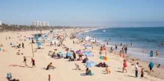 Crowded beach with people sunbathing and playing in the water
