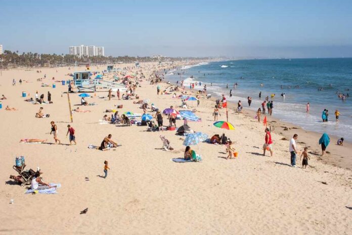 Crowded beach with people sunbathing and playing in the water