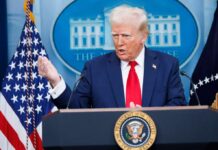 A government official speaking at a podium during a press conference