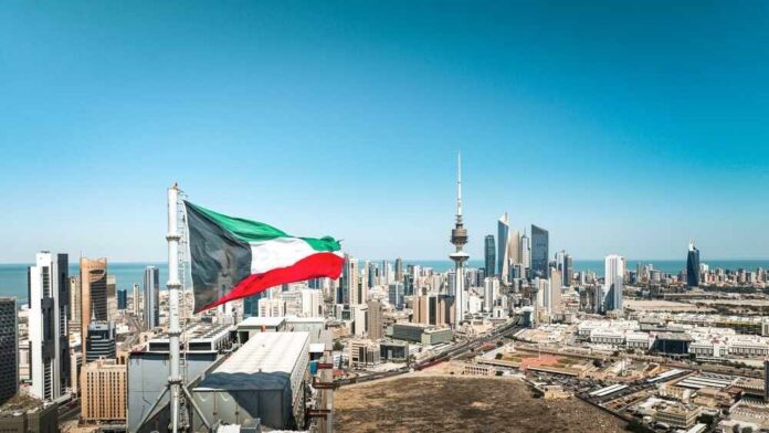 Kuwait flag waving over a city skyline with modern buildings