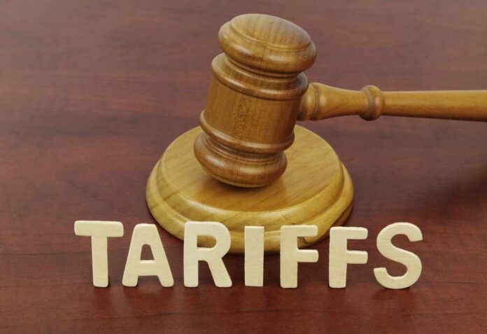 A wooden gavel next to the word 'TARIFFS' spelled out in wooden letters