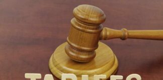 A wooden gavel next to the word 'TARIFFS' spelled out in wooden letters