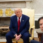 A group of political figures seated in a formal setting, with one individual looking contemplative