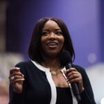 Unbelievable: Fugitive Ran Congresswoman’s Protection A woman speaking into a microphone at a conference