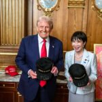 Shocking Trump-Takaichi Dinner Sparks Alliance Reset Two individuals holding hats with 'JAPAN IS BACK' text in a formal setting