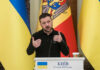 Ukrainian leader delivering a speech at a podium with national flags in the background