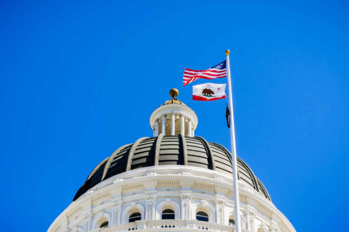 shutterstock_1070892341.jpg View of a state capitol dome with American and California flags against a blue sky