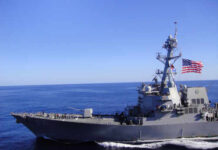 Strait of Hormuz Tensions EXPLODE – Navy on Edge A naval destroyer sailing in the ocean with an American flag