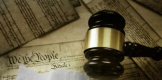 A gavel resting on a document labeled '25th Amendment' surrounded by historical papers