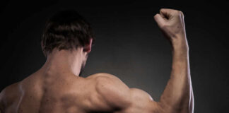 A muscular man flexing his arm from a back view