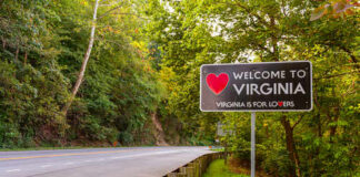 Welcome sign for Virginia along a tree-lined road