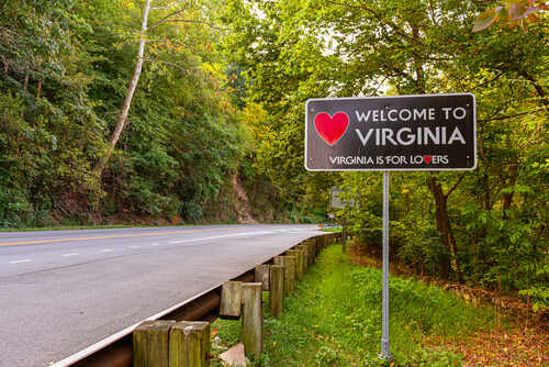 Welcome sign for Virginia along a tree-lined road