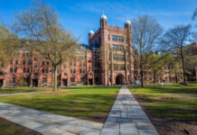 Historic university building surrounded by trees and a pathway