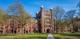 Historic university building surrounded by trees and a pathway