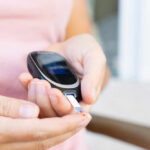 Person using a blood glucose meter to check their blood sugar level