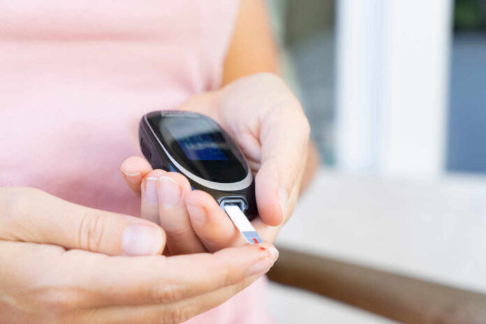 Person using a blood glucose meter to check their blood sugar level