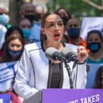 A speaker passionately addressing a crowd at a political rally