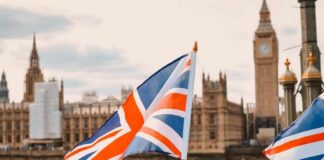 British flags in the foreground with the Houses of Parliament and Big Ben in the background
