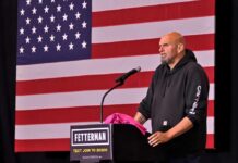 A speaker at a podium in front of an American flag during a political event