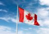 Canadian flag waving against a blue sky