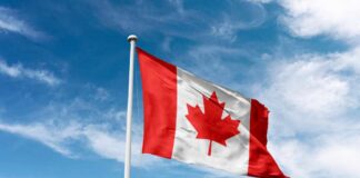 Canadian flag waving against a blue sky