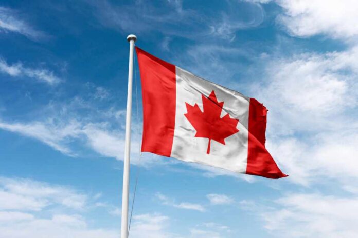 Canadian flag waving against a blue sky