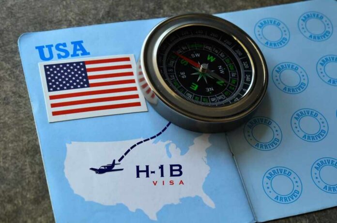 A compass placed on a travel document featuring an H-1B visa and a map of the USA